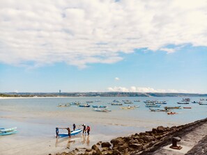 A beach with boats and people near the shore. - Familytel Bali (Kedonganan)