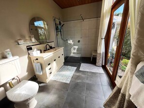 A modern bathroom with a shower, toilet, and sink.