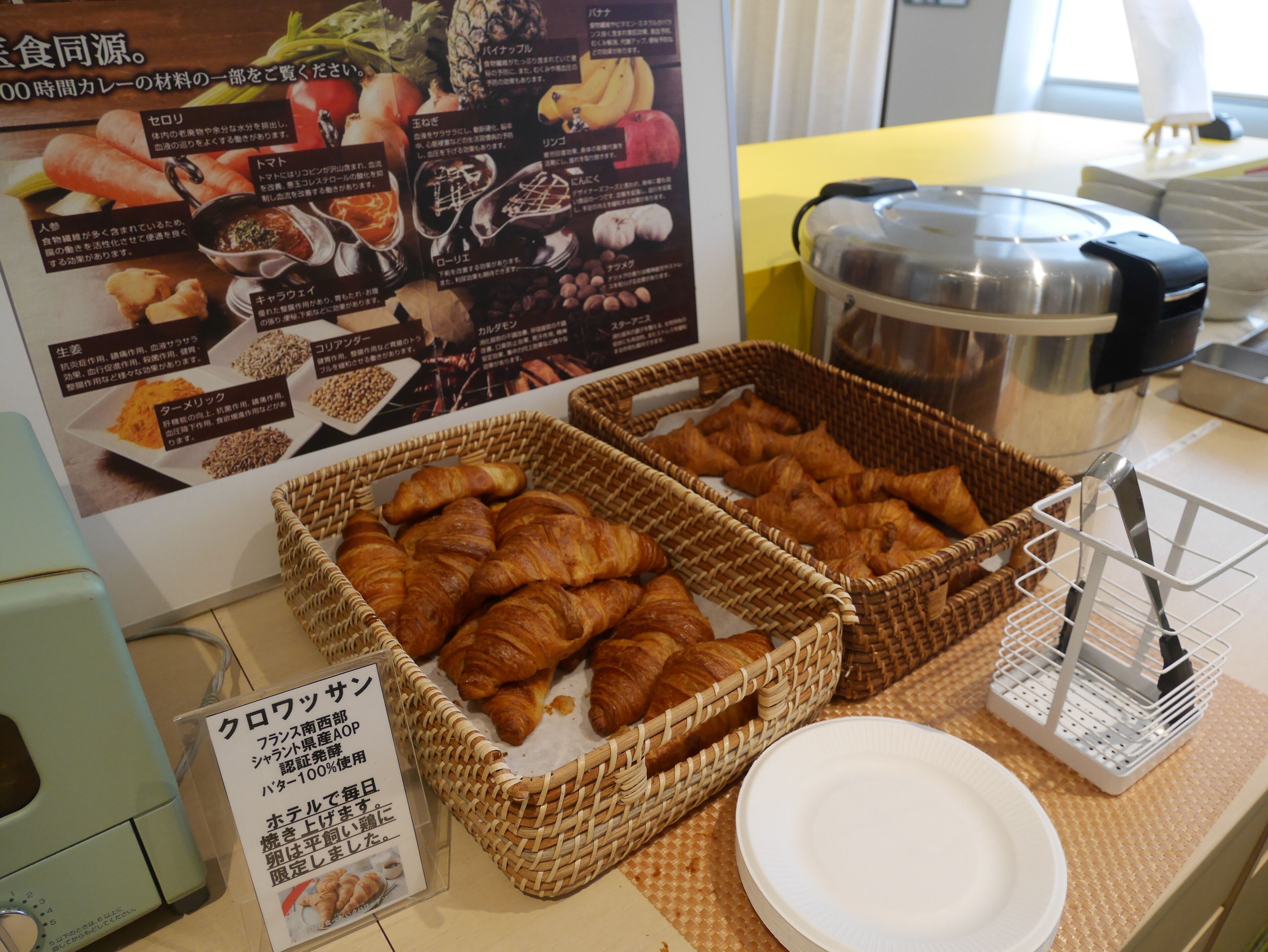 Un buffet della colazione con croissant e una caffettiera.