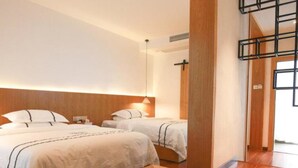 Ein Hotelzimmer mit zwei Betten, einem Holztisch mit Tee-Service und Blick nach draußen.