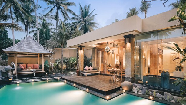 A modern resort with a swimming pool, outdoor seating, and a well-lit entrance. - Kuwarasan A Pramana Experience (Tegallalang)