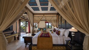 A spacious bedroom with a large bed, a nightstand, and a view of the outdoors. - Kuwarasan A Pramana Experience (Tegallalang)