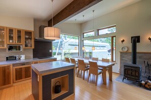 Une cuisine moderne avec des meubles en bois, un îlot central et un coin repas avec des chaises.