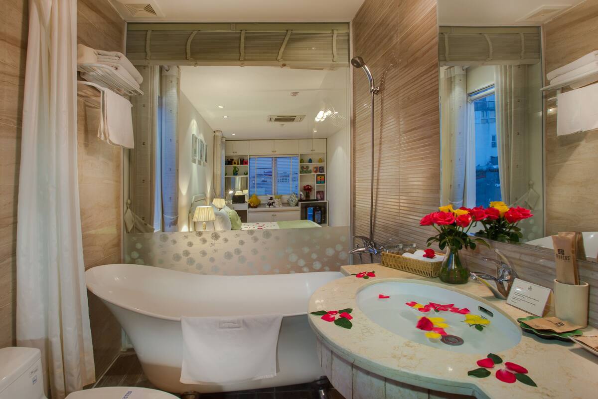 A modern bathroom with a freestanding bathtub, a vanity with a sink, and a large mirror.