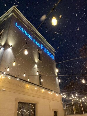 A building with a sign reading "LOUNGE BAR FUROR" and string lights.