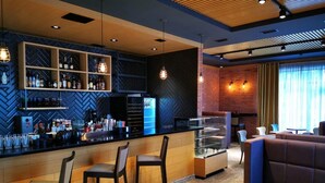 Zona de bar moderna con mostrador, taburetes y una vitrina.