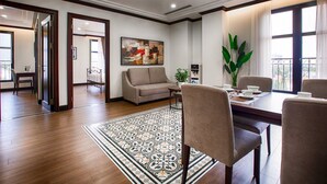 Un moderno appartamento con servizi, dotato di zona pranzo, soggiorno con divano, ampia finestra con vista e tappeto decorativo.