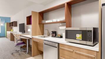 A modern kitchen with a built-in microwave, a coffee maker, and a dishwasher.