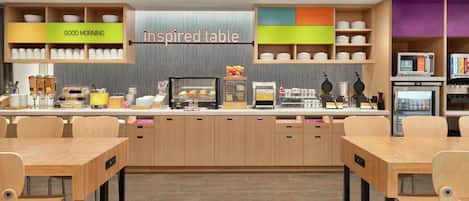 A modern cafe with a wooden counter, a display case with pastries, and a 'Good Morning' sign.