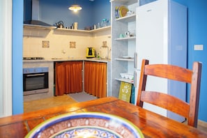 Apartamento básico, 1 quarto | Cozinha privada | Geladeira grande, micro-ondas, fogão, cooktop