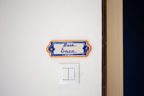 Eine an der Wand befestigte Schilder mit dem Namen "Casa Enza" und einem Lichtschalter darunter.