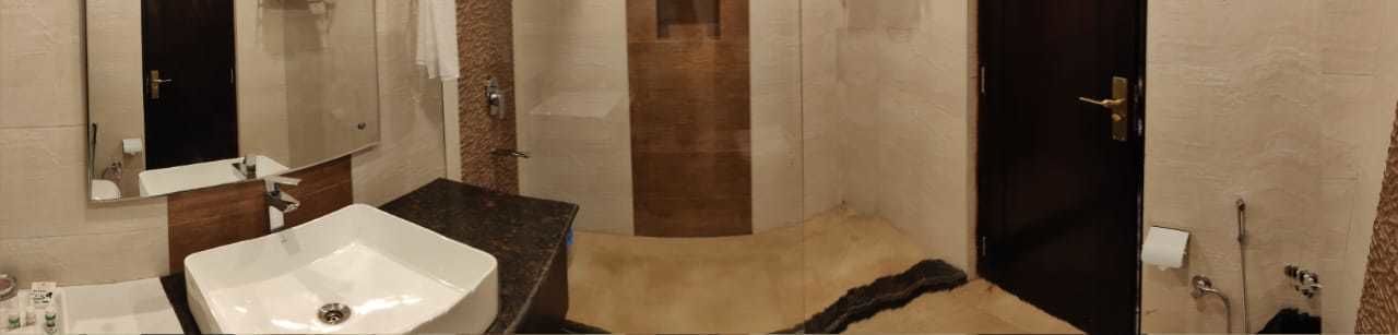 A bathroom with a large sink, mirror, and a shower area.