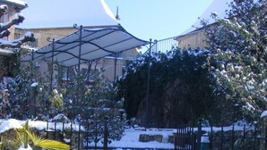 A snow-covered pathway leading to a gated entrance with a metal fence. - Hotel Coté Rivage (Badefols-sur-Dordogne)