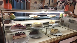 Una vitrina de pastelería con diversos pasteles y dulces.