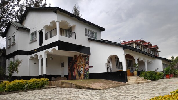 A two-story building with a balcony, a large mural, and a paved entrance area. - Casa Tulia Nakuru (Nakuru)