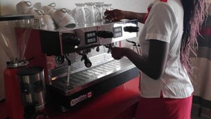 A person operating a coffee machine with multiple cups and a milk frother. - Casa Tulia Nakuru (Nakuru)