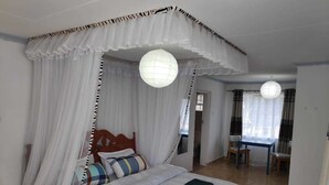 A bedroom with a canopy bed, a desk, and a chair. - Casa Tulia Nakuru (Nakuru)