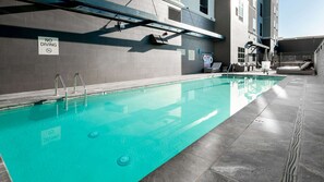 A swimming pool with a 'No Diving' sign, a lifeguard chair, and lounge chairs.