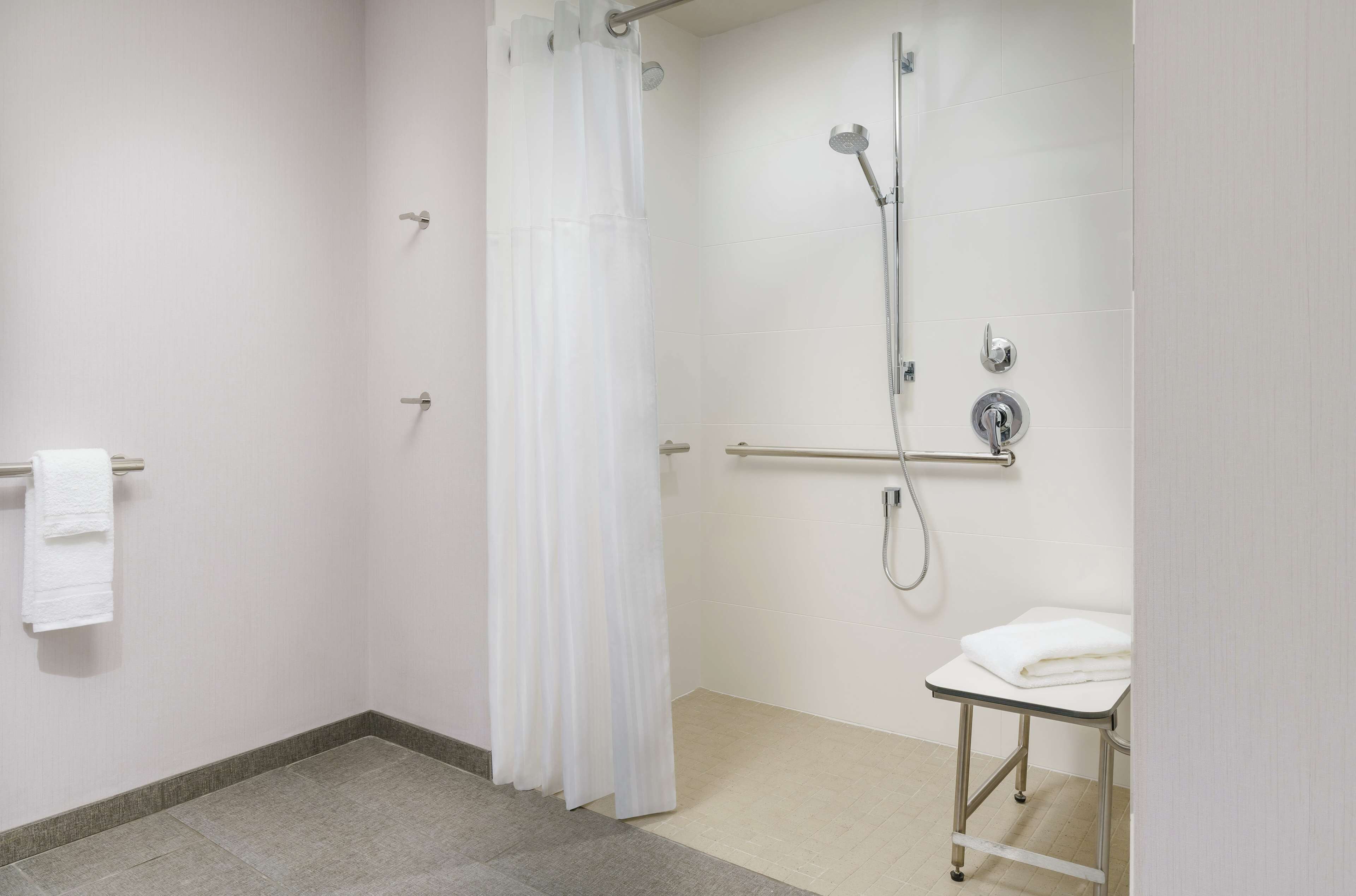 Ein modernes Badezimmer mit Dusche, Toilette und Handtuchhalter.