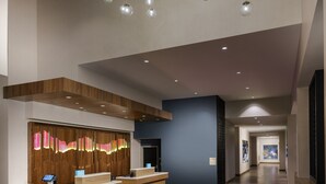 A spacious lobby with a reception desk, wooden paneling, and hanging spherical lights. - Hilton Garden Inn Sunnyvale (Sunnyvale)