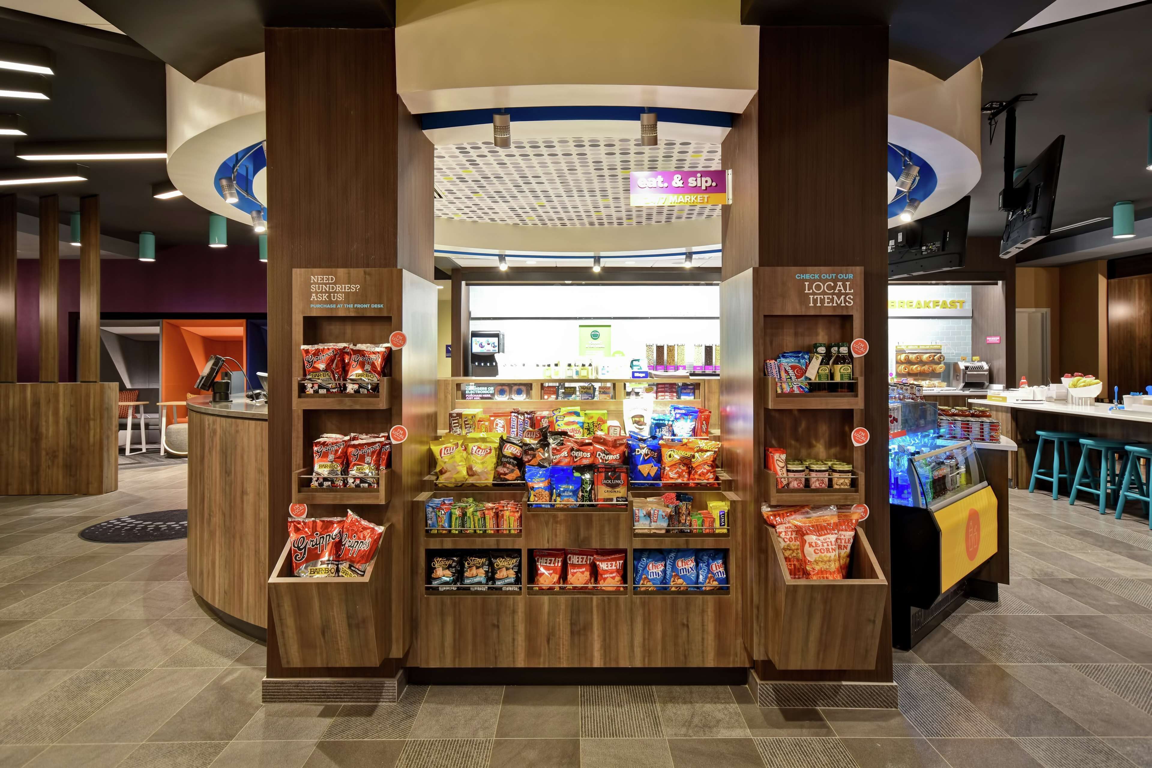A snack kiosk with various packaged snacks and a self-service beverage machine.
