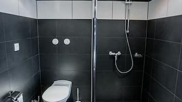 A modern bathroom with a toilet, bidet, and shower.