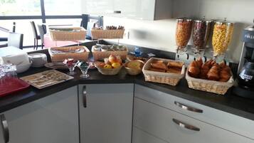Een ontbijtbuffet met verschillende gerechten en manden.