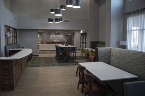 A spacious lobby with a reception desk, seating areas, and a 'Welcome to the Lobster State' sign. - Hampton Inn & Suites Portland West (Portland)