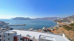 A coastal cityscape with a marina, residential buildings, and a bridge.