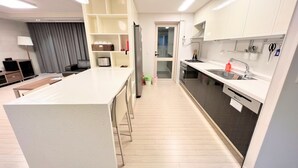 Una cocina moderna con una isla central, electrodomésticos integrados y una zona de comedor con mesa y sillas.