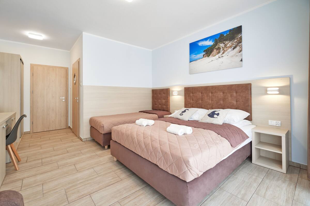 Ein Hotelzimmer mit zwei Betten, einem Schreibtisch und einem Stuhl.