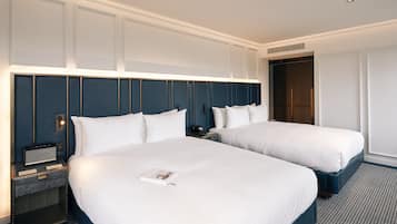 Ein Hotelzimmer mit zwei Betten, einem Nachttisch mit Lampe und einem fest installierten Lautsprecher.