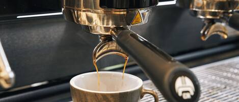A close-up of a coffee machine dispensing espresso into a cup.