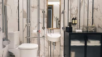A modern bathroom with a white toilet, a sink, and a black cabinet.
