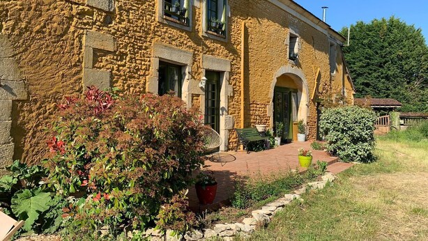 A stone building with a brick pathway, a bench, and potted plants. - Alfred and George, Le Gîte (Sainpuits)