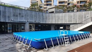 A community center with a blue pool surrounded by white pool ladders. - Seaside Arden (Seogwipo)