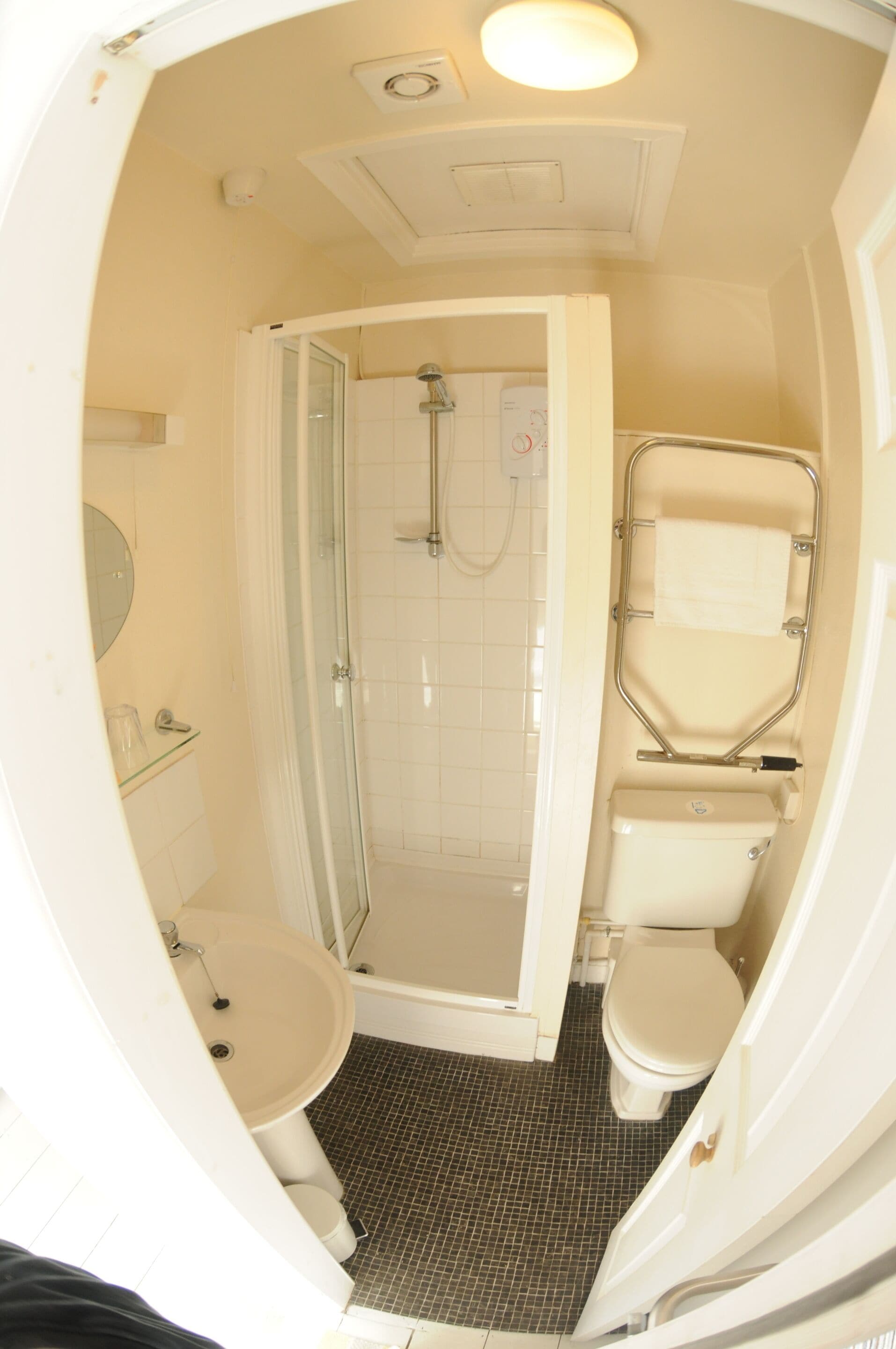 Un bagno con doccia, WC e lavandino.