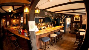 A bar area with stools, a counter, and various bottles. - Victoria Inn (Penzance)