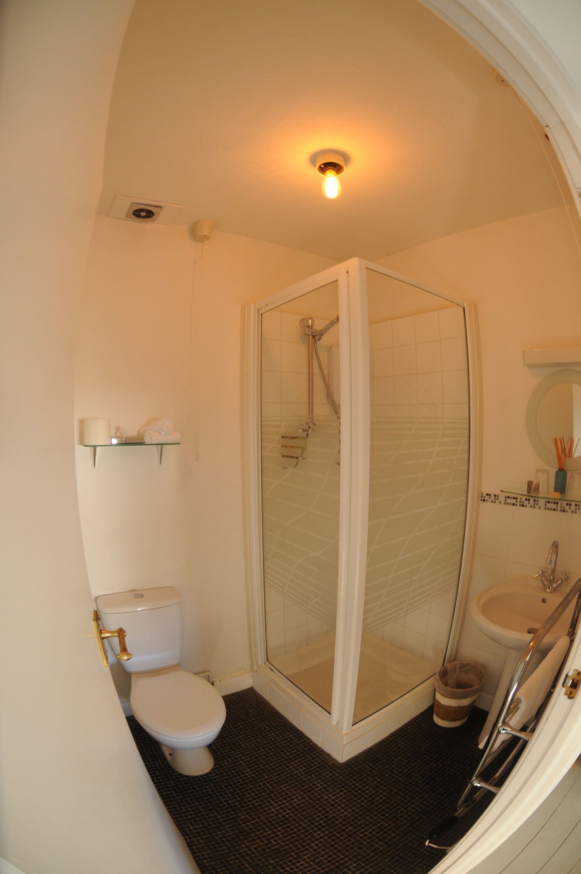 Une salle de bain compacte avec une douche à parois de verre, des toilettes et un lavabo.