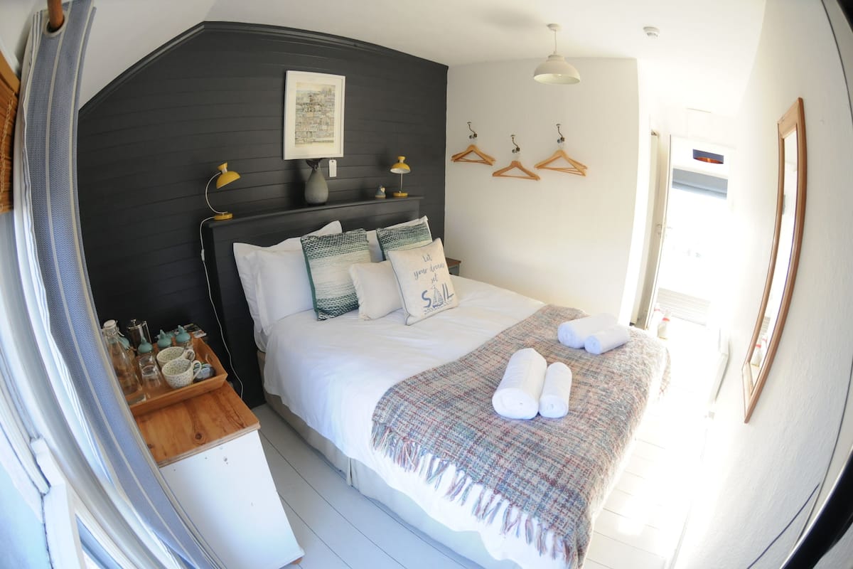 Une chambre à coucher avec un lit, une table de chevet et une fenêtre.