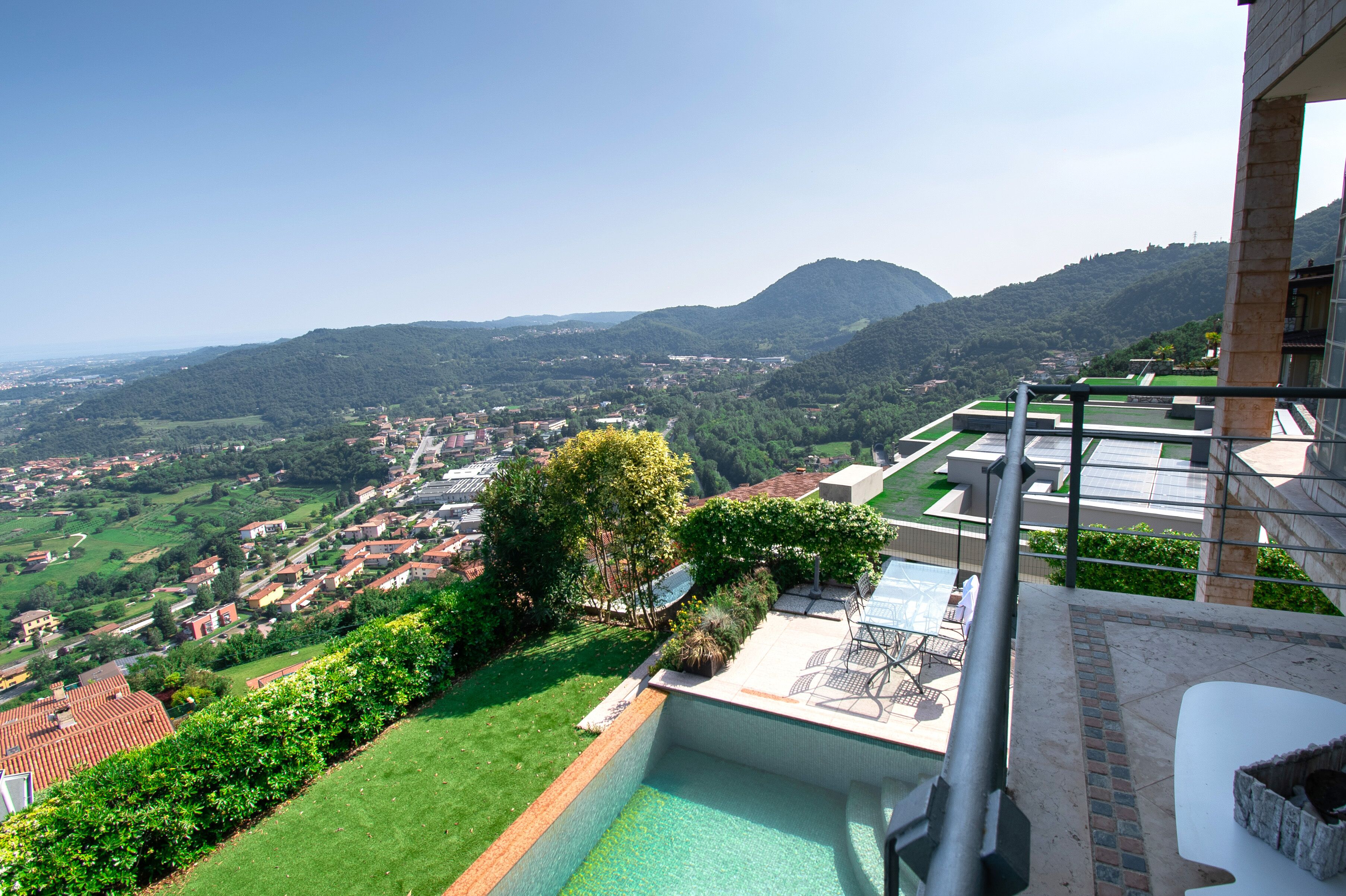 A poolside view with a clear view of a town and mountains in the background.