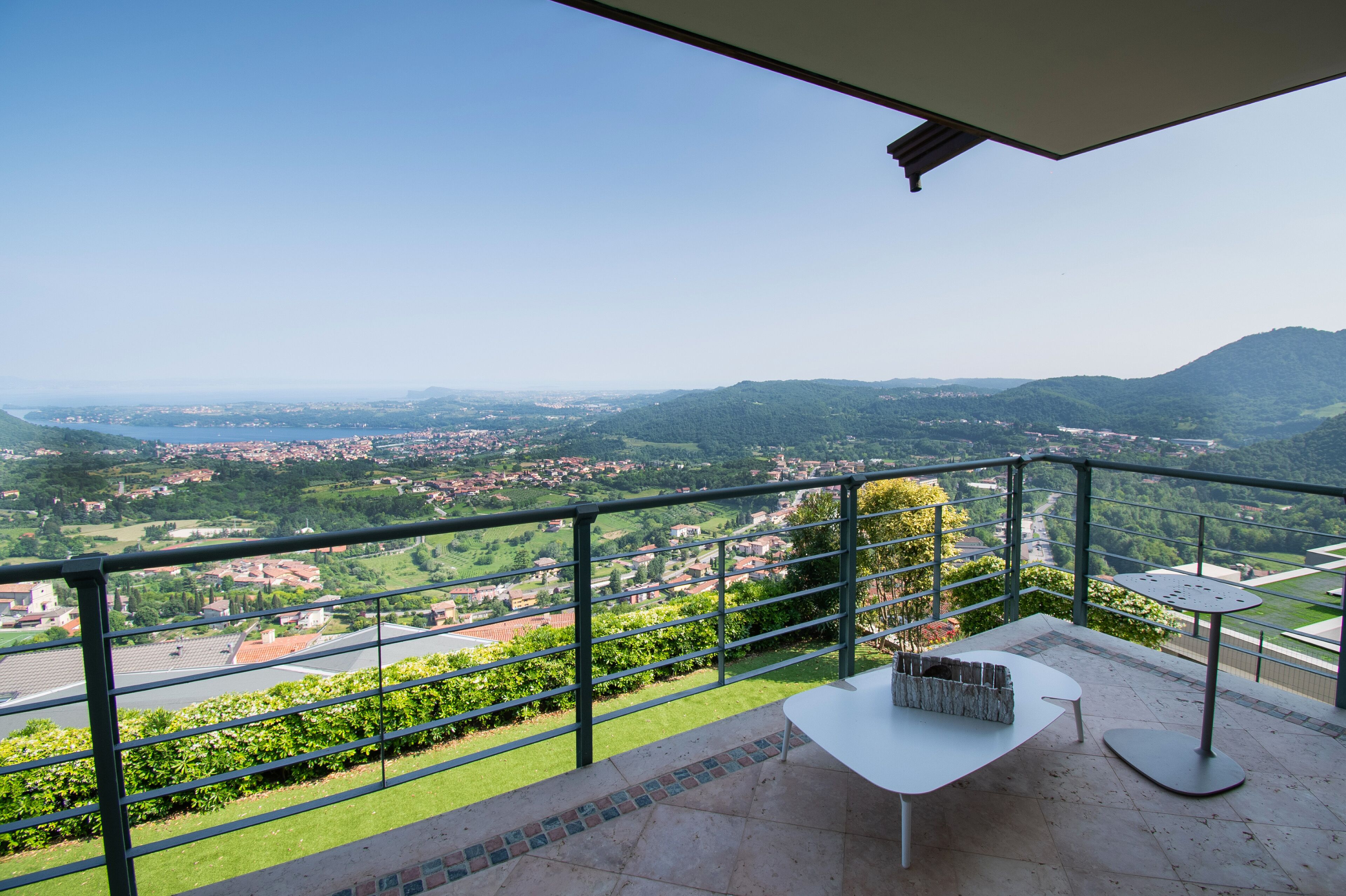 A balcony with a clear view of a town and hills.