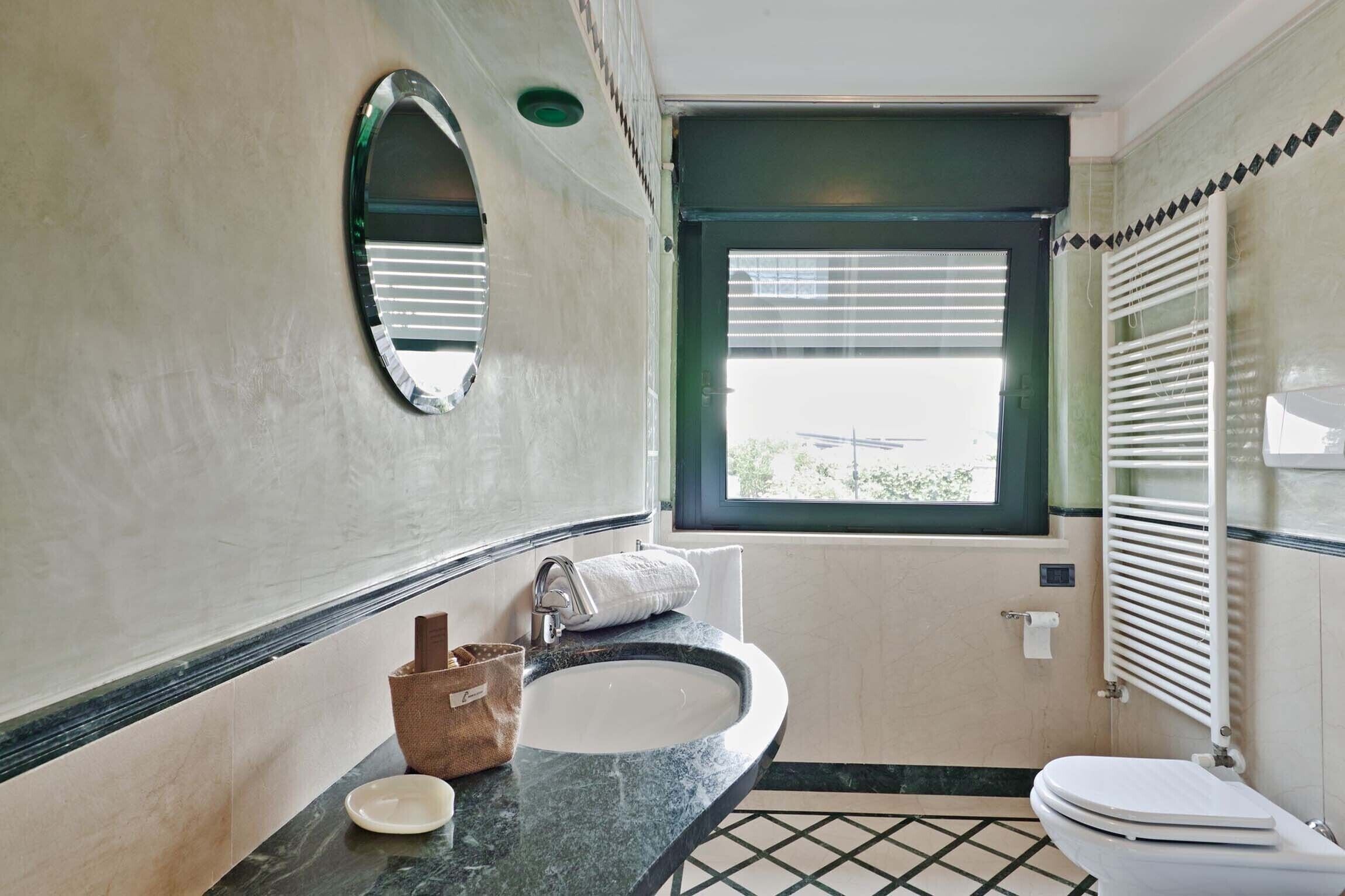 A bathroom with a sink, mirror, and toilet.