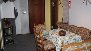 A dining area with a table set for two, surrounded by floral-patterned chairs. - Ferienwohnungen Hees (Emmerzhausen)