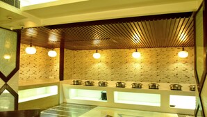 Una cucina moderna con pareti in mattoni a vista, illuminazione a sospensione e un'isola centrale con elettrodomestici integrati.