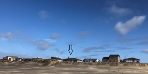 A coastal residential area with houses on sandy terrain under a clear sky. - Single Level, 2 King suites, on the beach, with 36" wide doors for accessibility (Waldport)