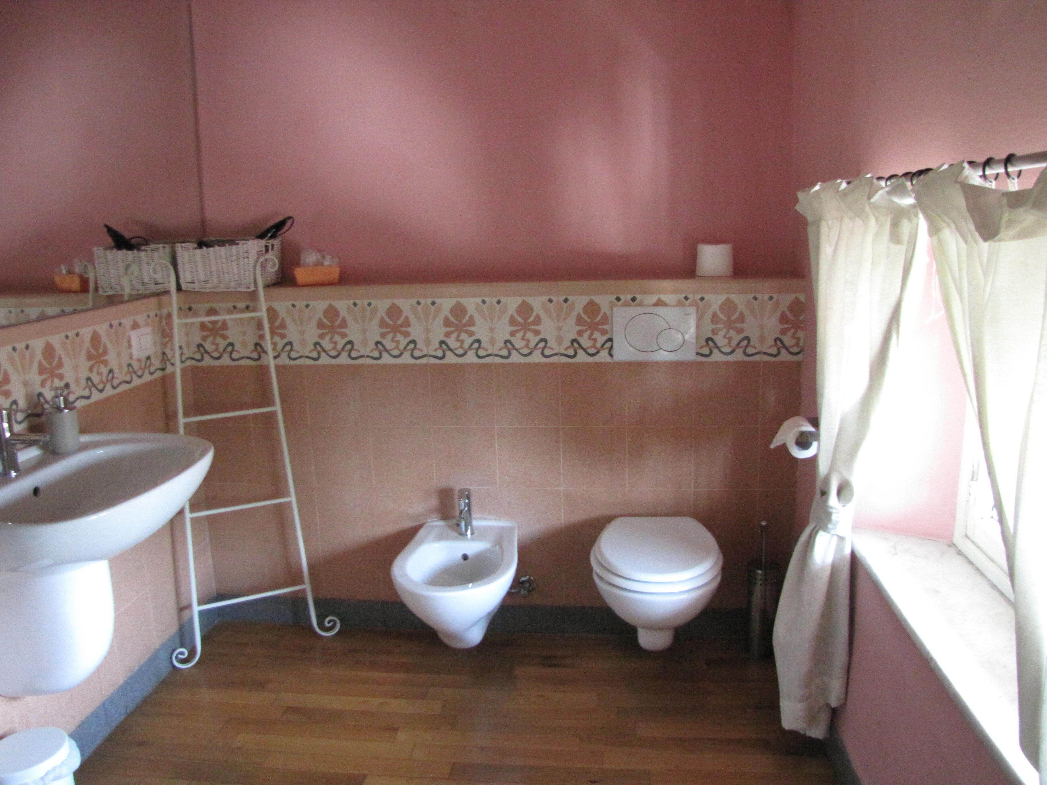 A bathroom with a bidet, toilet, and sink.