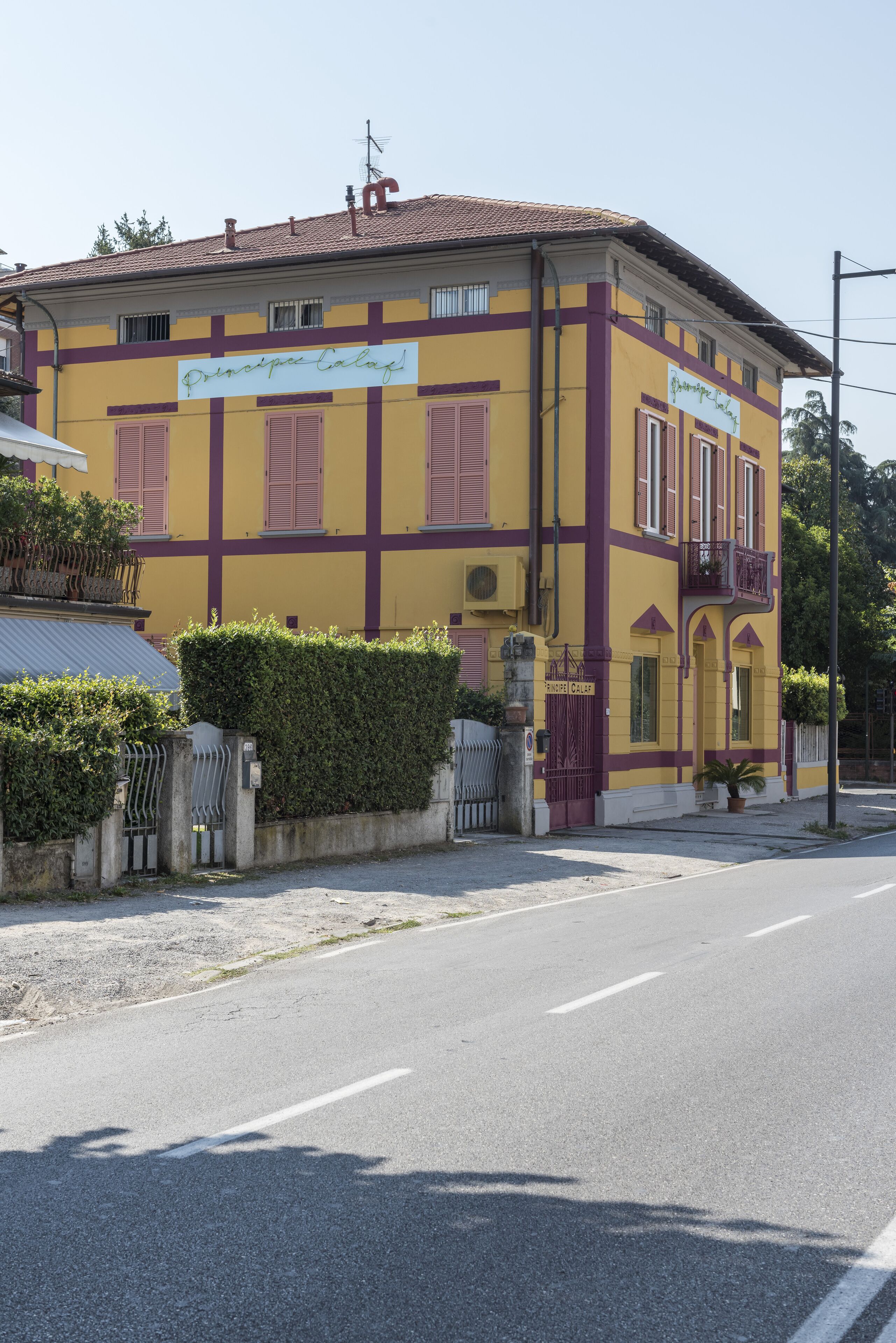 Un bâtiment jaune avec des ornements violets et une enseigne sur laquelle on peut lire « Principe Calaf ».