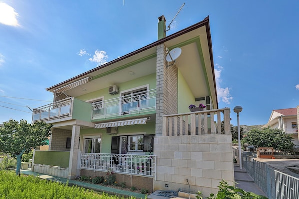 A two-story house with a balcony, satellite dish, and a small garden area. - Apartment 3M (Trogir)