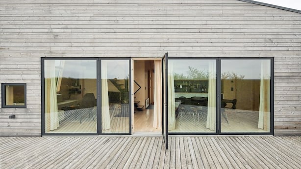 Un bâtiment moderne doté d’un toit en pente et de grandes fenêtres en verre.